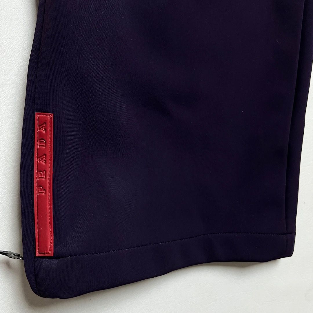 Authentic Prada Sport Technical Pants (Category: Joggers) located in Caloocan City. Submitted by achilles_grails (Listing ID 1470564345, Image 3). Description: - Brand: Prada Sport (Made in Italy) - Color: Deep purple - Fit: Straight leg with zipper hems - Details: Iconic red Prada logo tab near cuff, internal waist tag, and red inner piping - Material: Clean, structured fabric with slight stretch - Condition: Excellent vintage/archive piece - Id