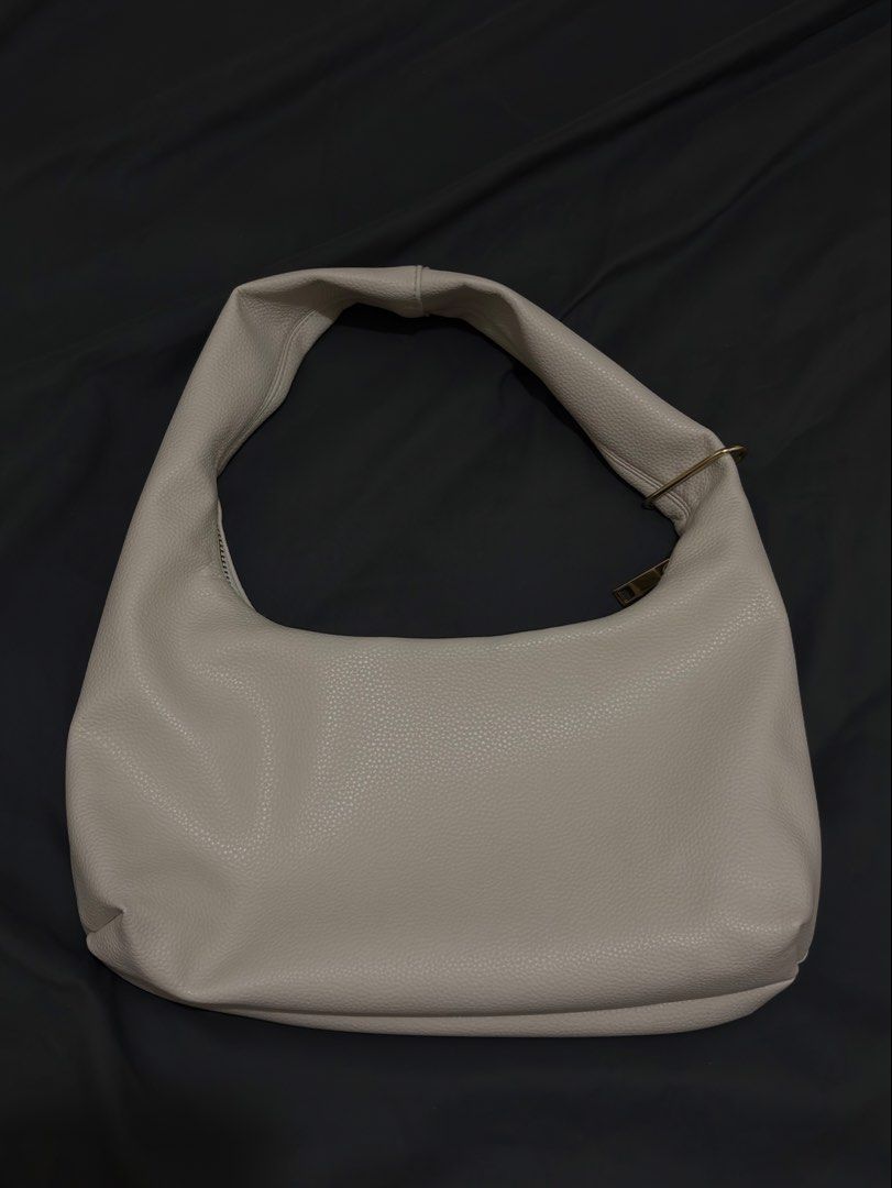 Aztrid Hobo Bag Beige (Small) (Category: Shoulder Bags) located in Manila. Submitted by prelovedbyhaze (Listing ID 1470672333, Image 2). Description: - Color: Creamy beige - Material: Pebbled faux leather with gold-tone hardware - Design: Structured slouchy shape with a secure top zip closure - Strap: Single shoulder strap designed for comfortable daily wear - Interior: Clean and spacious enough for essentials - Style: Minimalist and versatile, e
