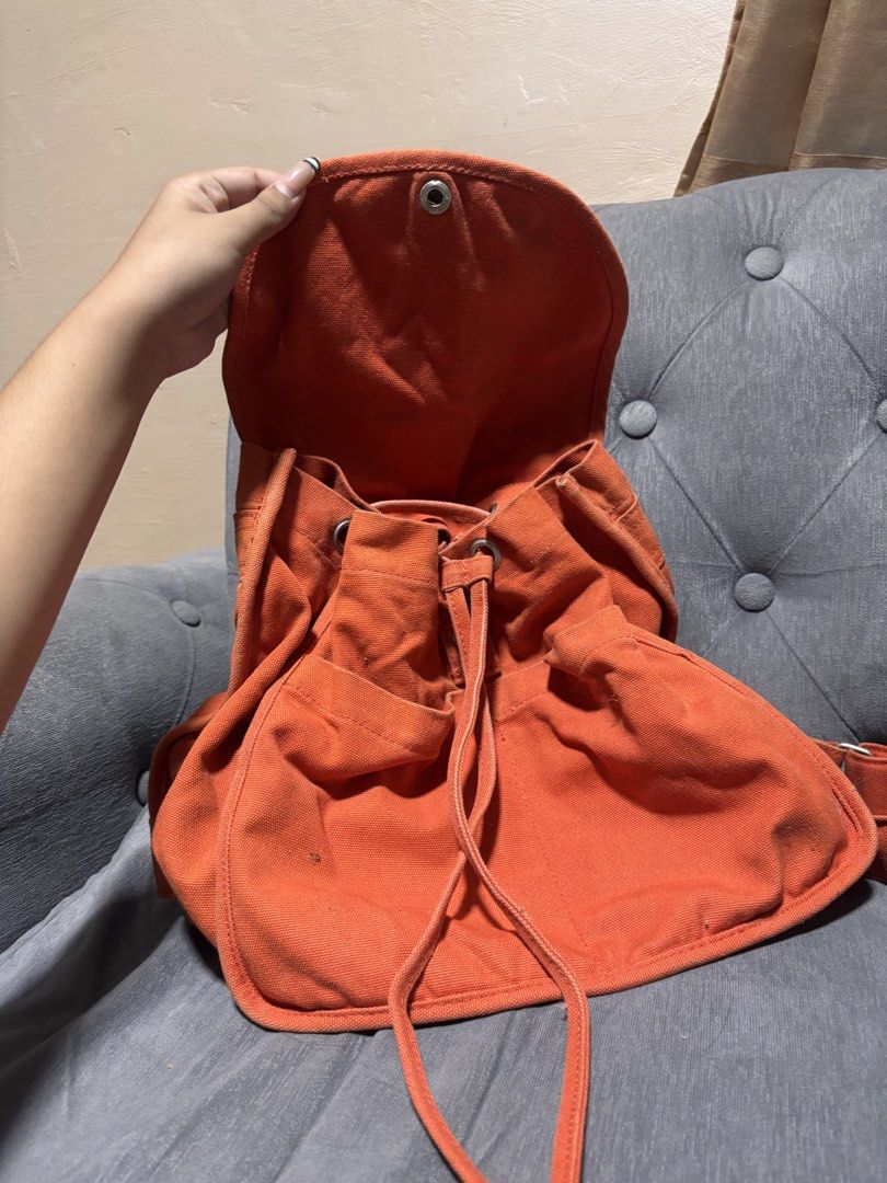 BAGGU Orange Canvas Backpack (Category: Backpacks) located in Manila. Submitted by alyanarein (Listing ID 1470724426, Image 2). Description: Bright orange BAGGU canvas backpack with a snap flap, drawstring closure, and front pocket. Clean and ready for daily use, school, or travel. Condi: 8/10.