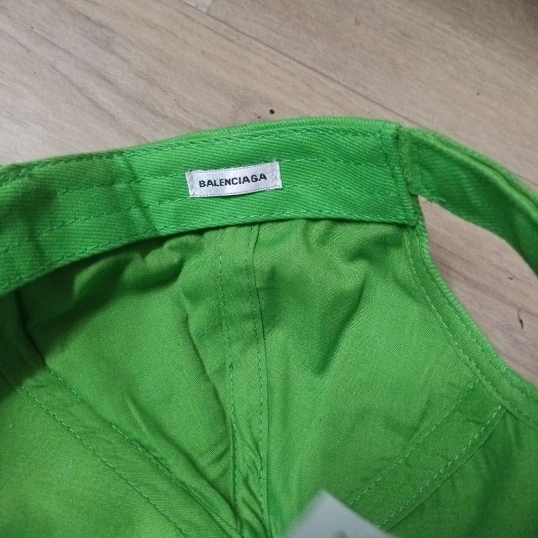 Balenciaga Neon Green Baseball Cap (Category: Caps & Hats) located in Manila. Submitted by itsnik444 (Listing ID 1470649070, Image 3). Description: - Brand: Balenciaga - Color: Bright green with black embroidered logo lettering on the brim - Material: 100% cotton, Made in China - Design: Classic six-panel construction with embroidered eyelets - Fit: Adjustable strap at the back for a customizable fit - Condition: Clean interior with original fabr