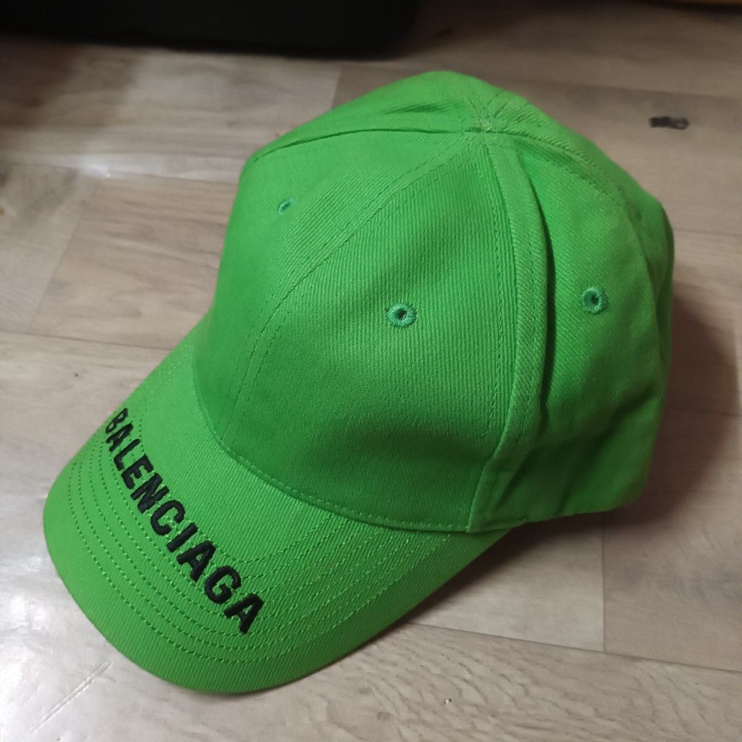 Balenciaga Neon Green Baseball Cap (Category: Caps & Hats) located in Manila. Submitted by itsnik444 (Listing ID 1470649070, Image 2). Description: - Brand: Balenciaga - Color: Bright green with black embroidered logo lettering on the brim - Material: 100% cotton, Made in China - Design: Classic six-panel construction with embroidered eyelets - Fit: Adjustable strap at the back for a customizable fit - Condition: Clean interior with original fabr