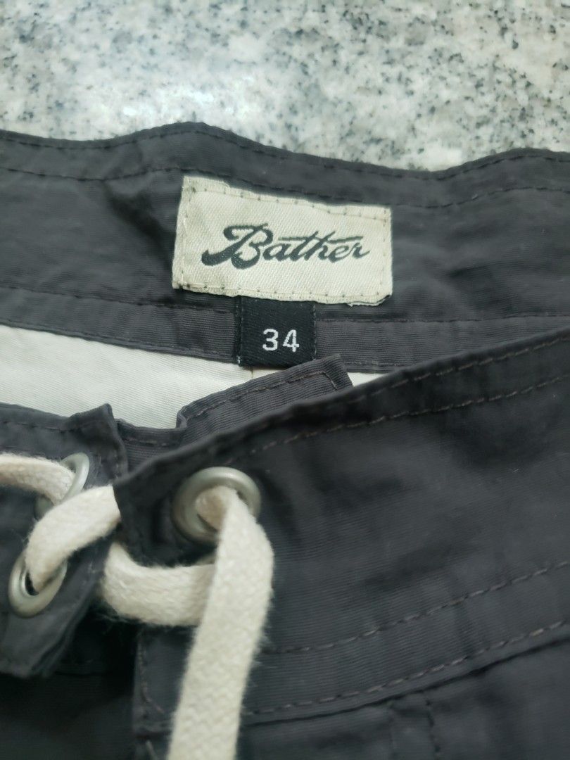 Bather Dark Grey Swim Trunks Size 34 (Category: Swim Trunks & Board Shorts) located in Pagsanghan. Submitted by yuchinz (Listing ID 1470660596, Image 3). Description: - Brand: Bather - Color: Solid dark grey - Size: 34 waist with adjustable drawstring closure - Material: 100% polyester shell, 100% nylon lining - Origin: Made in Canada - Details: Small woven Bather branding patch near the hem - Care: Machine wash cold, hang to dry.
