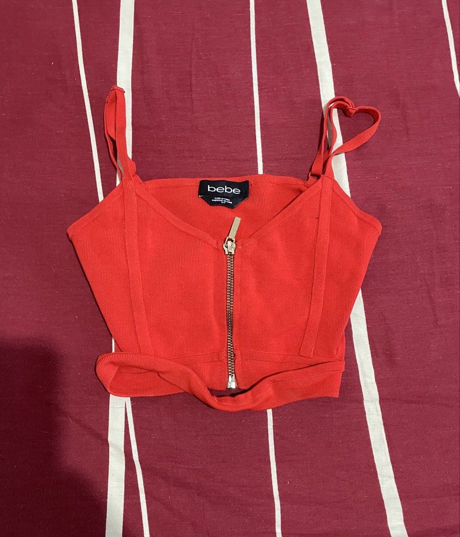 Bebe Red Ribbed Zip-Up Crop Top S/P (Category: Sleeveless) located in Manila. Submitted by alysaysyys_ (Listing ID 1470610590, Image 1). Description: - Brand: Bebe - Size: S/P - Color: Bright red - Material: Ribbed fabric - Details: Front metal zipper closure, thin spaghetti straps, structured front seaming - Condition: Clean and ready to wear.