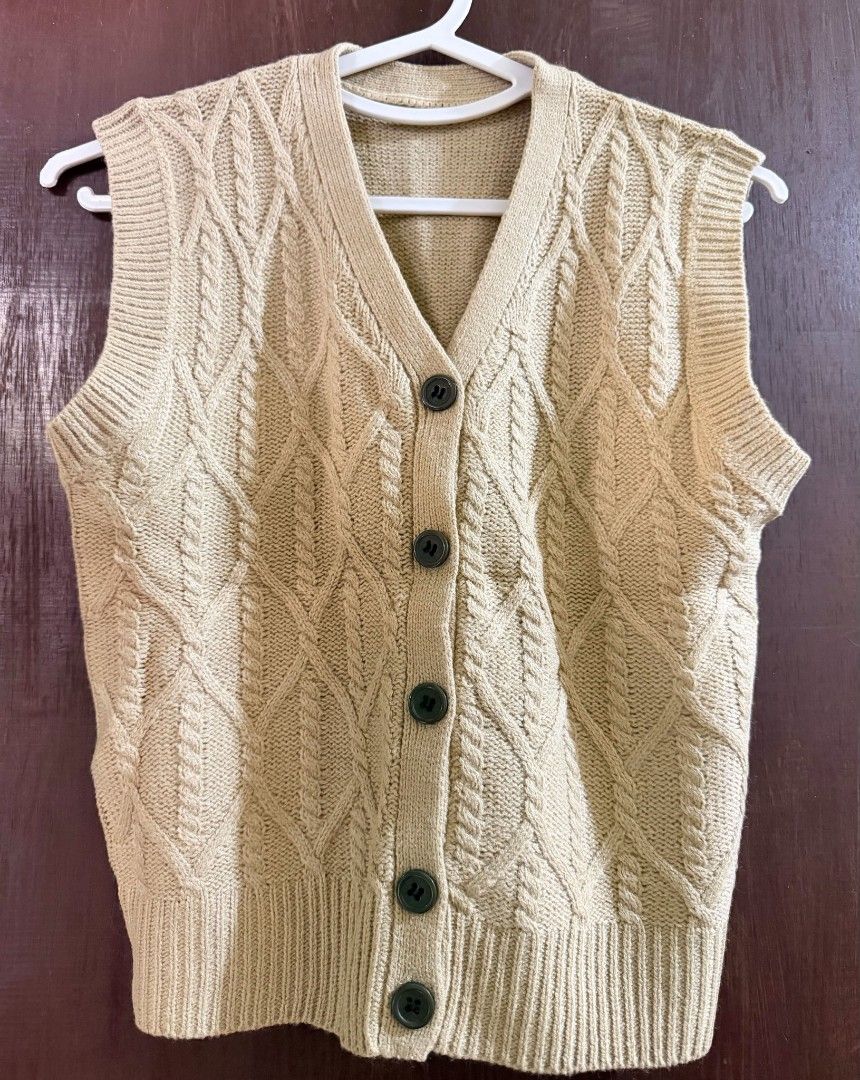 Beige Cable Knit Button-Up Sweater Vest (Category: Sleeveless) located in Taguig. Submitted by chicstyle (Listing ID 1470633617, Image 1). Description: - Color: Neutral beige - Design: Cable knit with V-neck and dark front buttons - Details: Ribbed hem and armholes for shape retention - Fabric: Soft and comfortable knit - Styling: Perfect for layering over shirts or wearing on its own.