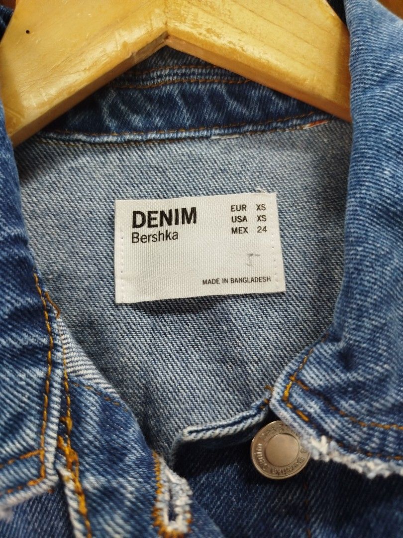 Bershka Denim Jacket Size XS (Category: Coats, Jackets and Outerwear) located in Quezon City. Submitted by epoquebyjaz (Listing ID 1470639611, Image 3). Description: - Brand: Bershka - Style: Casual oversized denim jacket - Color/Wash: Dark blue wash - Size: XS (Made in Bangladesh) - Details: Button-up front with metal hardware - Pockets: Two chest flap pockets and two side welt pockets - Edge: Trendy raw frayed hem and collar.