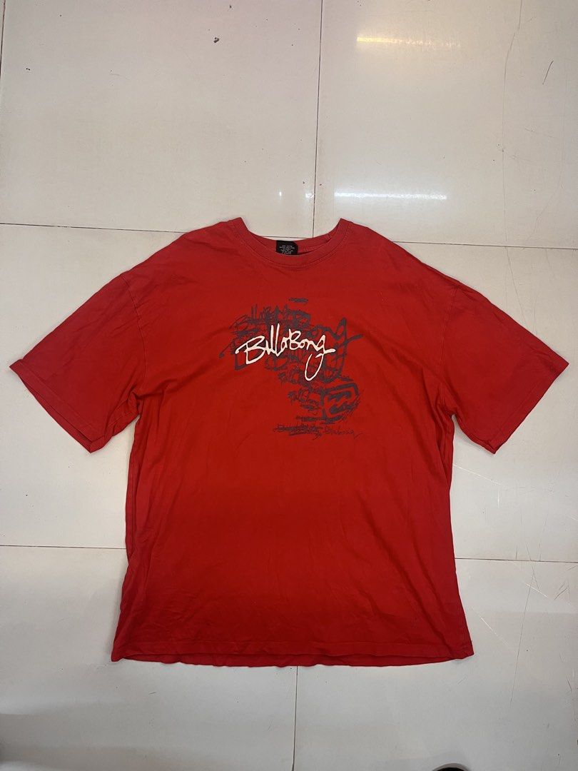 Billabong Red Graphic T-Shirt (Category: Tshirts & Polo Shirts ) located in Dagupan City. Submitted by shanadongsb (Listing ID 1470603264, Image 1). Description: - Brand: Billabong - Color: Red - Size: 56 (Relaxed oversized fit) - Material: 100% Cotton - Design: Large layered graphic print on front chest with white and charcoal logo, plus small script logo on upper back - Care: Machine wash warm.