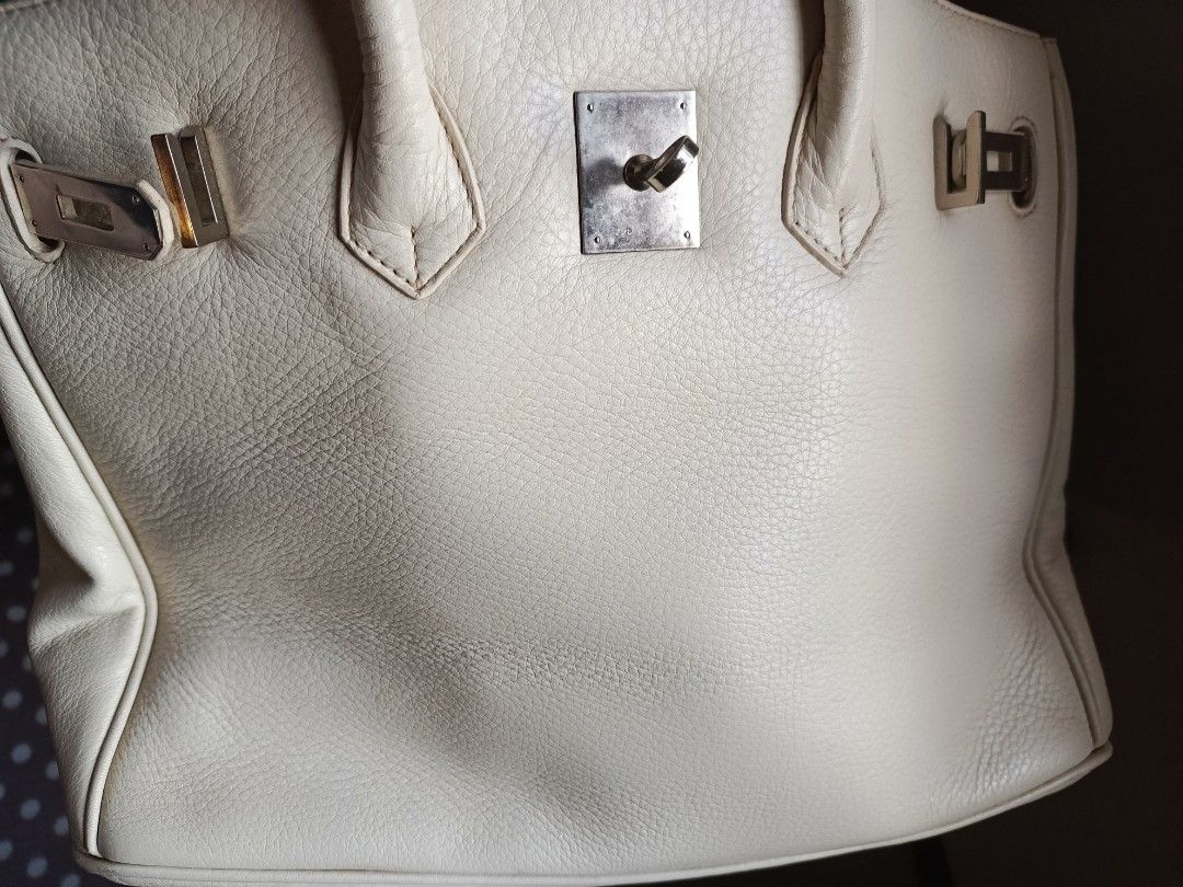 Birkin White Leather Handbag (Category: Luxury Bags & Wallets) located in Marikina City. Submitted by wisebuytoo (Listing ID 1470594574, Image 2). Description: With FREE one woven Handbag - Color & Material: Cream white grained leather - Hardware: Silver-tone with minor wear - Closure: Classic front turn-lock - Handles: Double top handles for easy carry - Interior: Lined with a zipper pocket and signature 'H' zipper pull - Protection: Metal feet 