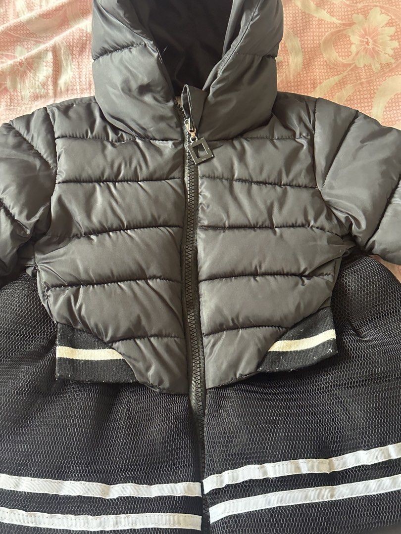 Black Puffer Coat with Hood Size M (Category: Babies & Kids Fashion) located in Malabon City. Submitted by rasclosetandstuffs (Listing ID 1470679066, Image 3). Description: - Brand/Model: QHFS kids hooded puffer coat - Size: M (measures approx. 18 inches in total length) - Design: Stylish quilted top section with a sporty flared mesh bottom and double white stripes - Closure: Convenient front zipper - Features: Attached hood for extra warmth - Co