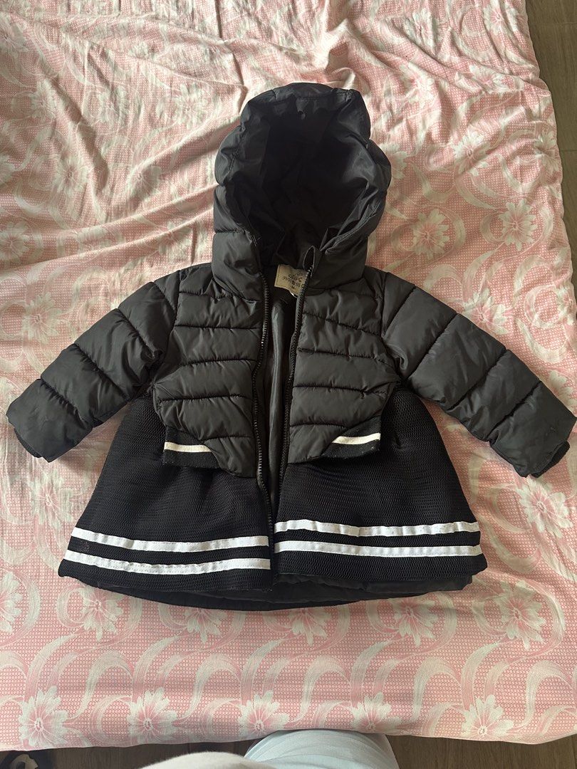 Black Puffer Coat with Hood Size M (Category: Babies & Kids Fashion) located in Malabon City. Submitted by rasclosetandstuffs (Listing ID 1470679066, Image 1). Description: - Brand/Model: QHFS kids hooded puffer coat - Size: M (measures approx. 18 inches in total length) - Design: Stylish quilted top section with a sporty flared mesh bottom and double white stripes - Closure: Convenient front zipper - Features: Attached hood for extra warmth - Co