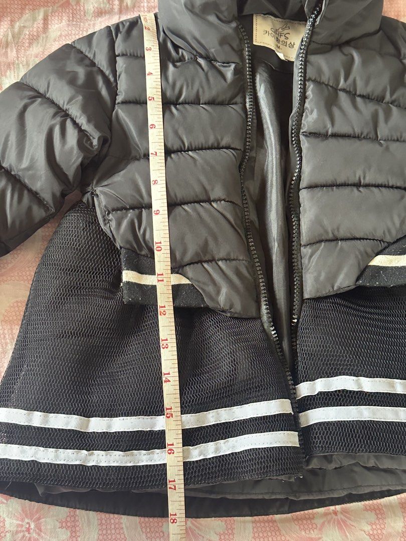 Black Puffer Coat with Hood Size M (Category: Babies & Kids Fashion) located in Malabon City. Submitted by rasclosetandstuffs (Listing ID 1470679066, Image 2). Description: - Brand/Model: QHFS kids hooded puffer coat - Size: M (measures approx. 18 inches in total length) - Design: Stylish quilted top section with a sporty flared mesh bottom and double white stripes - Closure: Convenient front zipper - Features: Attached hood for extra warmth - Co