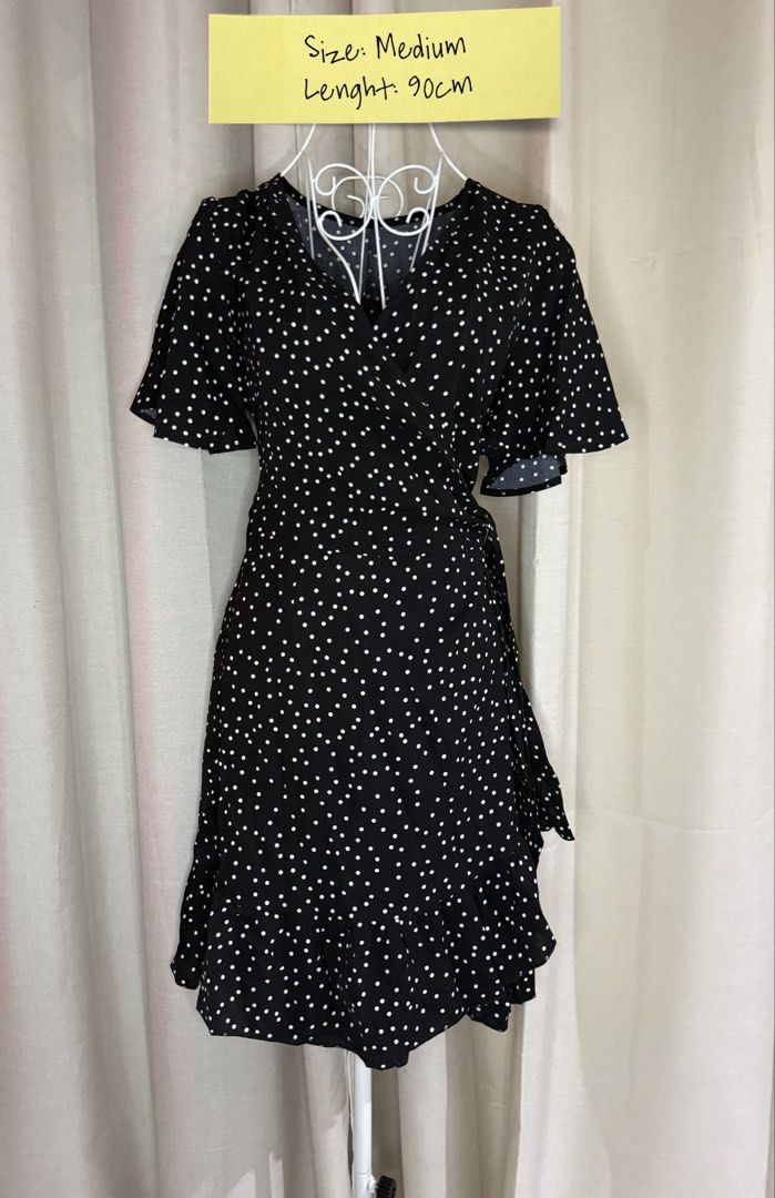 Black White Polka Dot Wrap Dress Medium 90cm (Category: Dresses) located in Cebu City. Submitted by jovjovcim60300 (Listing ID 1470697627, Image 1). Description: Black wrap dress with white polka dots all over. Short flutter sleeves, V-neckline, and a ruffled hem detail. Tie-wrap side closure. Length measures 90cm. Size medium. Lightweight fabric, easy to style for casual outings or weekend wear..