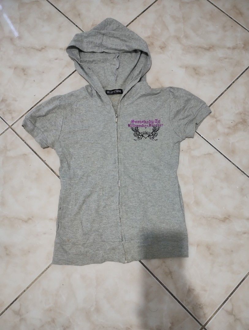 Blue Strive Grey Short Sleeve Zip Hoodie with Graphics (Category: Activewear) located in Imus. Submitted by darylg88358770 (Listing ID 1470645769, Image 1). Description: - Brand/Style: Blue Strive grey short sleeve zip-up hoodie - Aesthetic: True Y2K streetwear vibe - Design: Small glittery purple/black front graphic; large winged cross back graphic with "Somebody To Remember Forever" and "Old Friends In Better Times" text - Details: Attached hoo