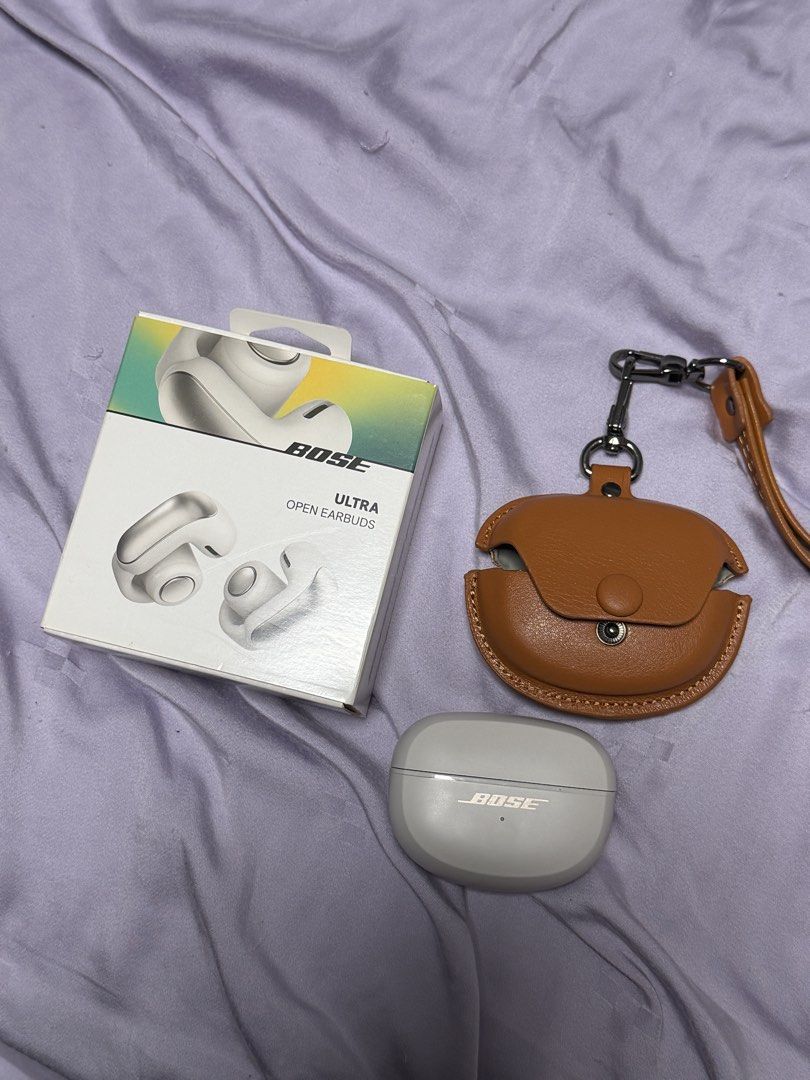 Bose Ultra Open Earbuds (Category: Headphones & Headsets) located in Pasay City. Submitted by chinscollection2021 (Listing ID 1470660379, Image 1). Description: - Model: Bose Ultra Open Earbuds - Color: White Smoke - Condition: Clean, fully tested, and working perfectly with minimal handling marks - Included: Original charging case, USB-C cable, retail box, plus a bonus brown leather protective case with strap pendant - Features: Innovative open-
