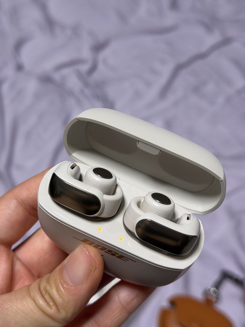 Bose Ultra Open Earbuds (Category: Headphones & Headsets) located in Pasay City. Submitted by chinscollection2021 (Listing ID 1470660379, Image 2). Description: - Model: Bose Ultra Open Earbuds - Color: White Smoke - Condition: Clean, fully tested, and working perfectly with minimal handling marks - Included: Original charging case, USB-C cable, retail box, plus a bonus brown leather protective case with strap pendant - Features: Innovative open-