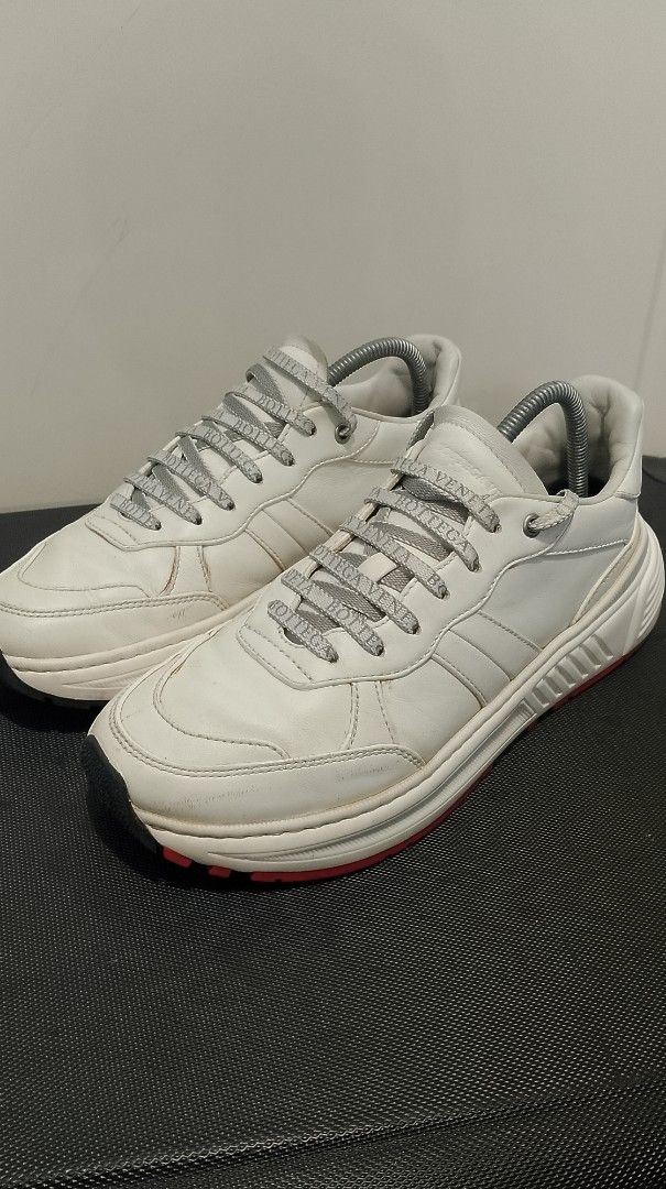 Bottega Veneta White Leather Sneakers (Category: Sneakers & Footwear) located in Pasig City. Submitted by lonski1181 (Listing ID 1470687396, Image 1). Description: - Brand: Bottega Veneta - Color: White with red sole accents - Material: Premium leather upper and lining - Features: Chunky platform sole, branded logo laces, embossed tongue logo, branded insoles - Origin: Made in Italy - Condition: Normal signs of wear visible on the leather uppers 