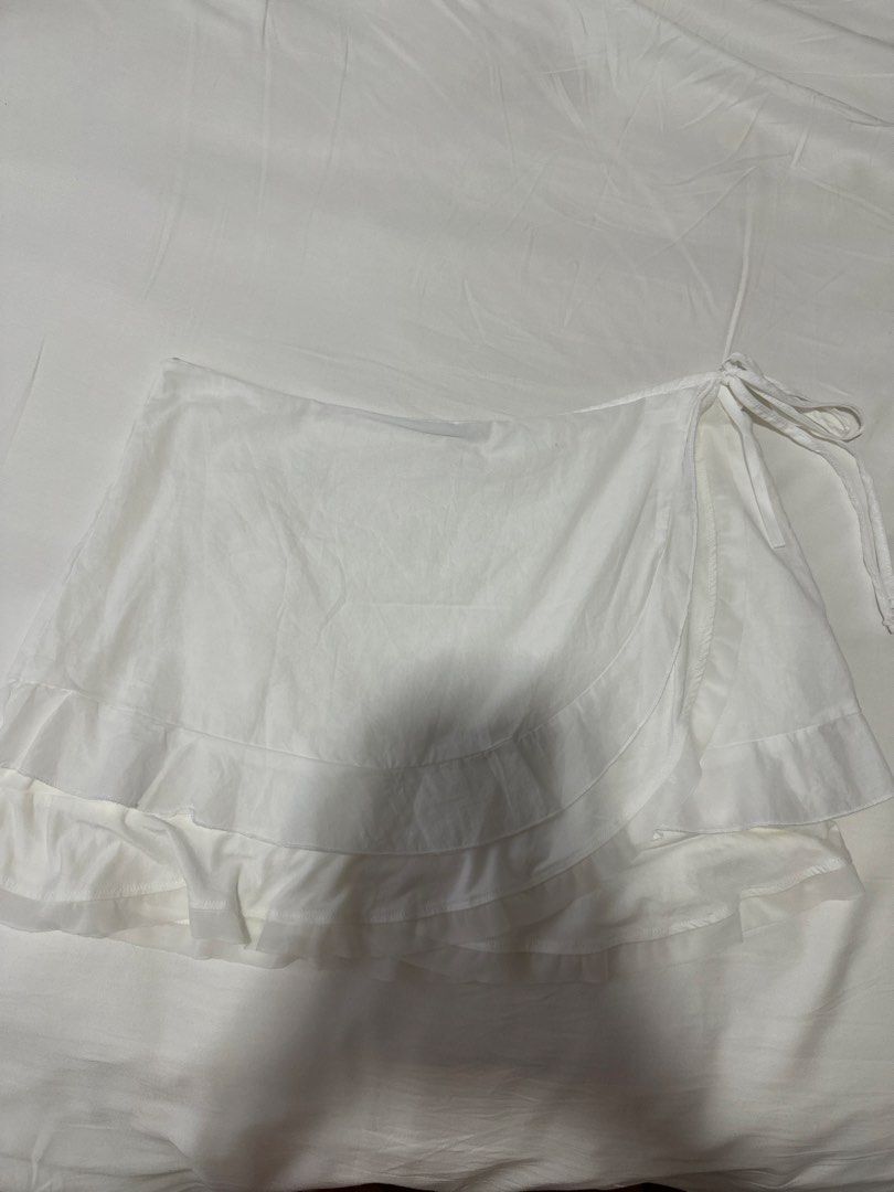 Brandy Melville White Ruffle Wrap Skirt (Category: Skirts) located in Taguig. Submitted by aandco. (Listing ID 1470687693, Image 1). Description: - Brand new without tags - bought from Brandy Shanghai - last price, already selling lower - BGC area.