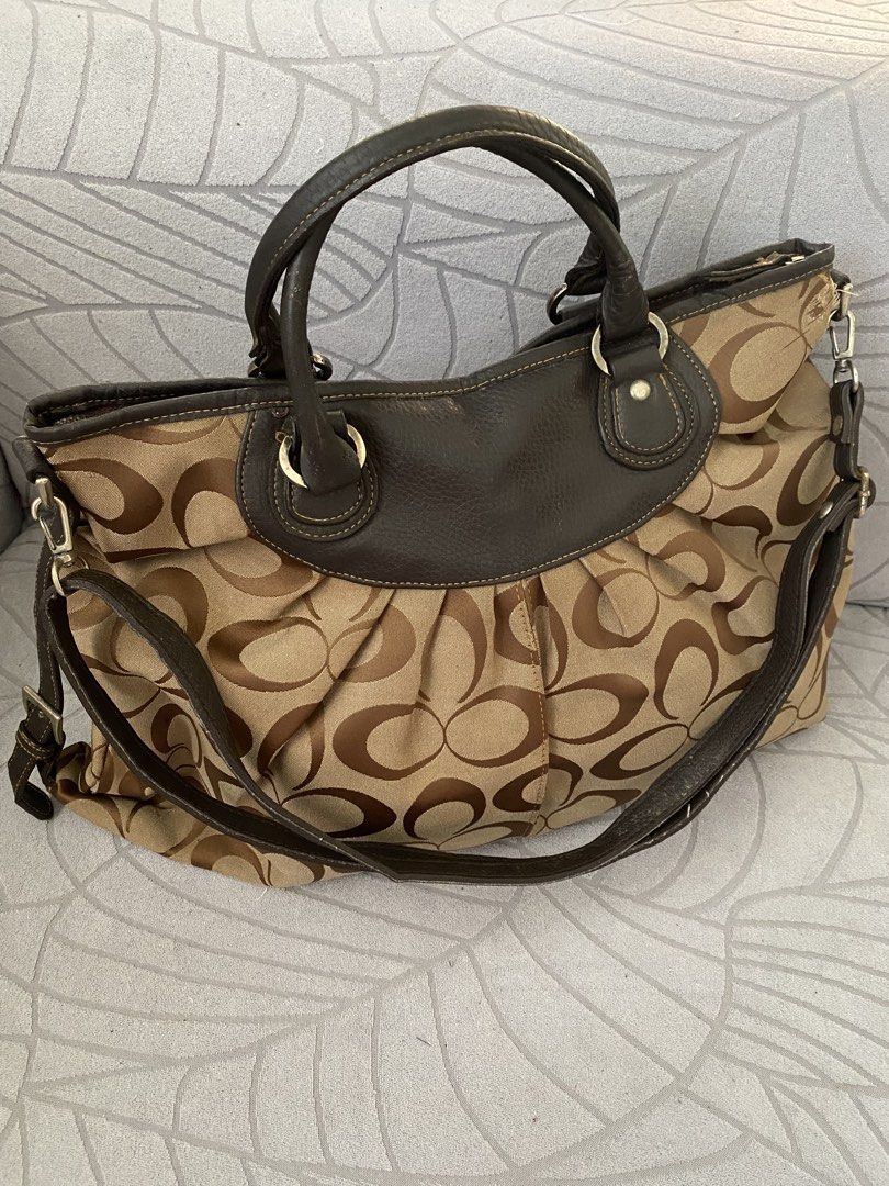 Brown Canvas Hobo Shoulder Bag (Category: Luxury Bags & Wallets) located in Calapan. Submitted by kimmieartsycraft (Listing ID 1470625740, Image 3). Description: - Brand: Coach - Material: Signature C jacquard fabric with dark brown leather trim - Design: Chic pleated front and back body with zip top closure - Straps: Dual top handles plus a detachable, adjustable shoulder strap with metal hardware - Interior: Spacious and lined with fabric - Con
