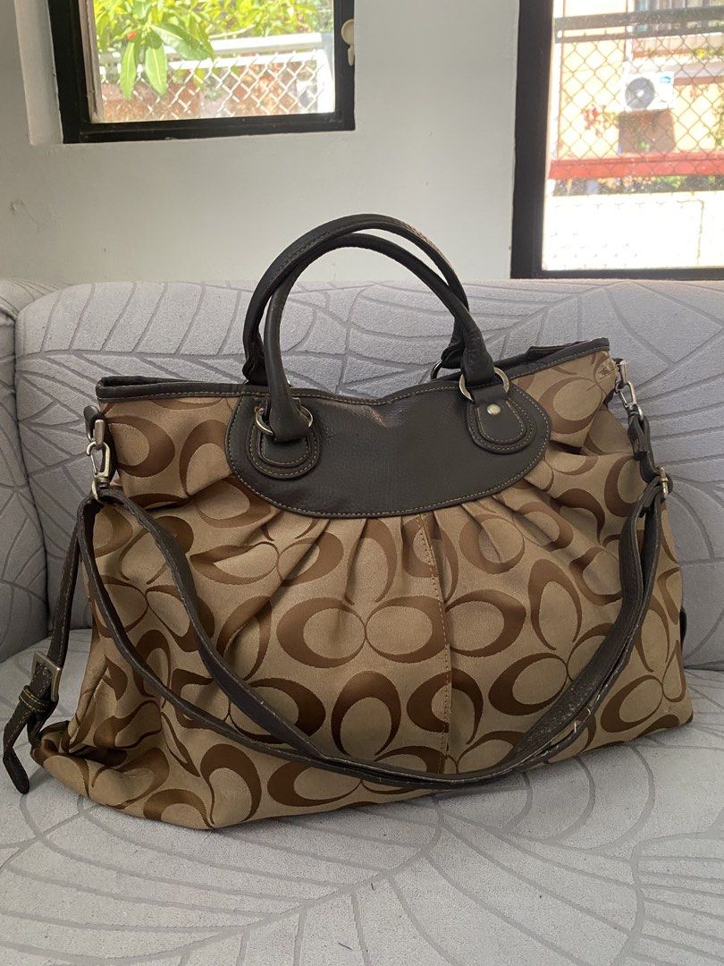 Brown Canvas Hobo Shoulder Bag (Category: Luxury Bags & Wallets) located in Calapan. Submitted by kimmieartsycraft (Listing ID 1470625740, Image 1). Description: - Brand: Coach - Material: Signature C jacquard fabric with dark brown leather trim - Design: Chic pleated front and back body with zip top closure - Straps: Dual top handles plus a detachable, adjustable shoulder strap with metal hardware - Interior: Spacious and lined with fabric - Con