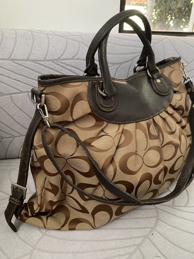 Brown Canvas Hobo Shoulder Bag (Category: Luxury Bags & Wallets) located in Calapan. Submitted by kimmieartsycraft (Listing ID 1470625740, Image 2). Description: - Brand: Coach - Material: Signature C jacquard fabric with dark brown leather trim - Design: Chic pleated front and back body with zip top closure - Straps: Dual top handles plus a detachable, adjustable shoulder strap with metal hardware - Interior: Spacious and lined with fabric - Con