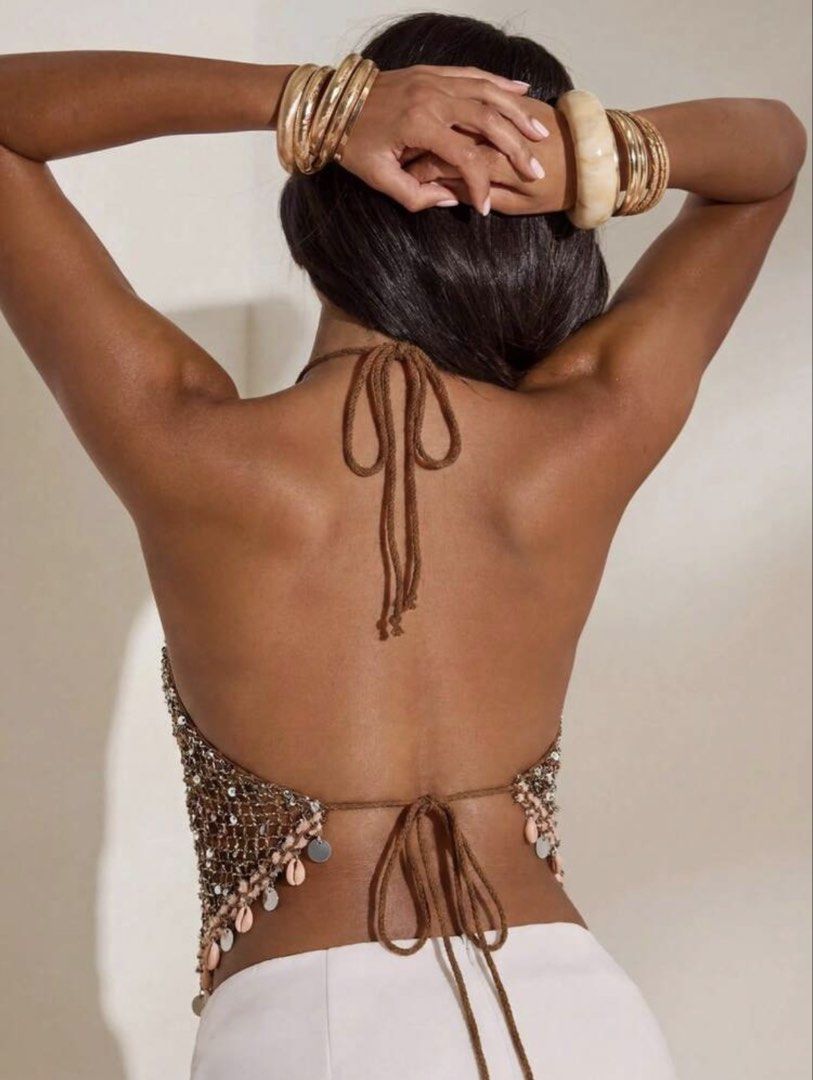 Brown Sequin Halter Top With Shell Fringe (Category: Sleeveless) located in Manila. Submitted by ayeka.finds (Listing ID 1470678588, Image 2). Description: - Brown mesh halter top covered in sparkly sequins - Trendy pointed hemline with dangling seashells and metallic disks - Adjustable neck and lower back tie closures for a custom fit - Sexy open-back design made from lightweight knit material - Ideal for beach vacations, music festivals, and su