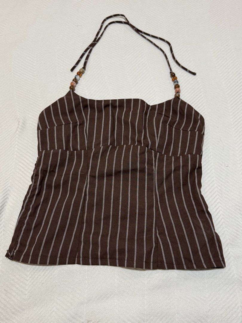 Brown Striped Halter Top with Beaded Straps (Category: Sleeveless) located in Pateros City. Submitted by daisy03052000 (Listing ID 1470677281, Image 1). Description: - Brown halter top featuring white vertical stripes - Unique beaded detail along the straps - Size: Medium (tag attached) - Closure: Convenient side zipper - Material: Cotton blend with light structure - Perfect for summer days and night outs - Easy to pair with denim shorts or skirt