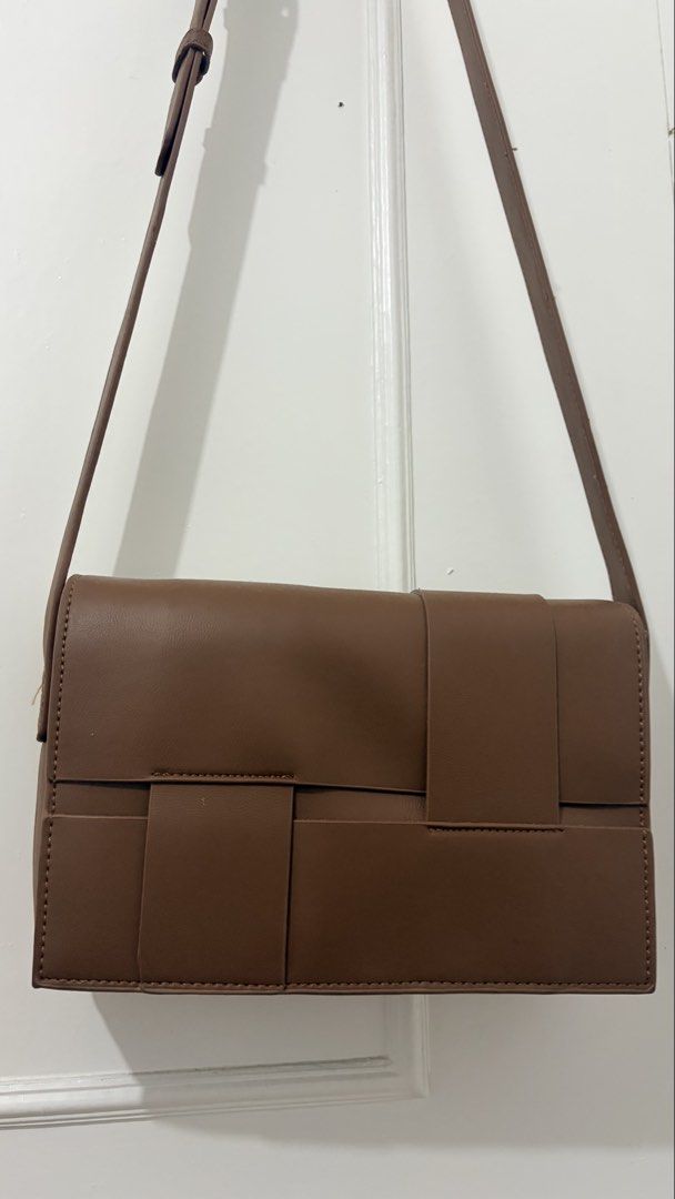 Brown Woven Flap Crossbody Bag (Category: Cross-body Bags) located in Dasmarinas. Submitted by rammonton (Listing ID 1470581948, Image 2). Description: - Color: Brown - Material: Faux leather with distinctive woven front flap - Hardware: Silver-toned with adjustable shoulder strap - Interior: Clean, lined with black patterned fabric, features a zippered middle divider and slip pockets - Condition: Well-maintained structure - Perfect size for dail