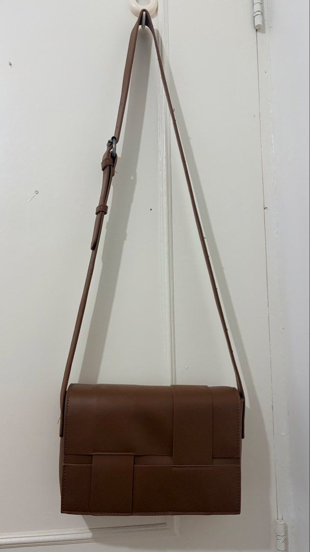 Brown Woven Flap Crossbody Bag (Category: Cross-body Bags) located in Dasmarinas. Submitted by rammonton (Listing ID 1470581948, Image 3). Description: - Color: Brown - Material: Faux leather with distinctive woven front flap - Hardware: Silver-toned with adjustable shoulder strap - Interior: Clean, lined with black patterned fabric, features a zippered middle divider and slip pockets - Condition: Well-maintained structure - Perfect size for dail