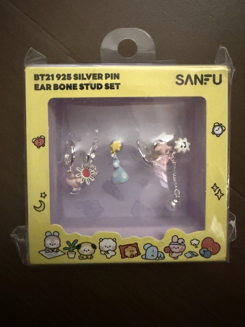 BT21 Cooky 925 Silver Pin Ear Bone Stud Set Sanfu (Category: K-Wave Merchandise) located in Marikina City. Submitted by culose (Listing ID 1470587484, Image 1). Description: - Authentic BT21 925 silver pin ear bone stud set by Sanfu - Includes multiple character-themed earrings with cute dangling charms (flowers, stars, little figures) - 100% brand new and unopened - Plastics still intact inside original yellow retail box with clear window displa