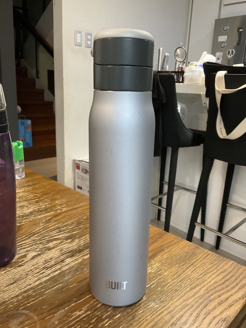 Built Stainless Steel Water Bottle Silver Grey (Category: Water Bottles & Tumblers) located in Manila. Submitted by momfinds.mnl (Listing ID 1470618895, Image 2). Description: - Brand: Built - Color/Material: Silver grey stainless steel - Lid: Push-button mechanism with a lock switch to prevent accidental spills - Design: Wide mouth opening for easy cleaning and adding ice cubes - Performance: Keeps drinks hot or cold throughout the day - Conditi