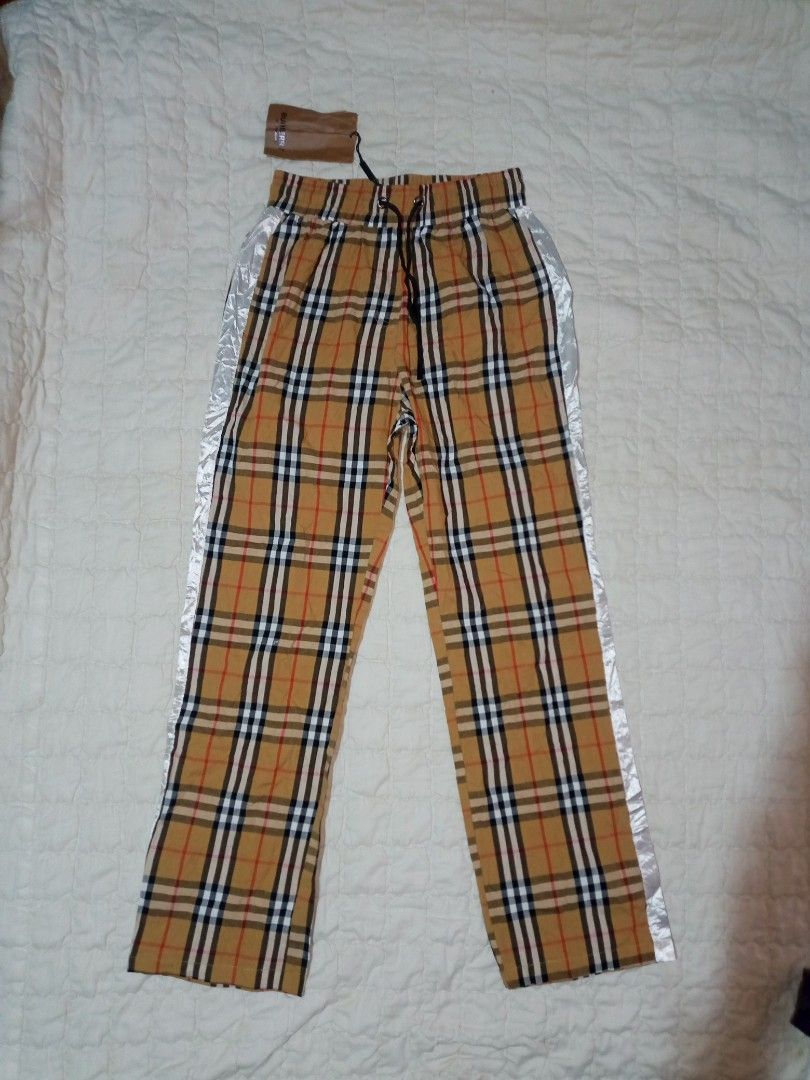 Burberry Check Drawstring Trousers (Category: Trousers) located in Allen. Submitted by milyonaryung_gipit (Listing ID 1470567133, Image 1). Description: - Brand: Burberry - Style: Check print trousers with distinctive side stripes - Size: Medium - Material: 100% cotton - Features: Elastic waistband with adjustable black drawstring - Condition: Brand new with original tag attached.