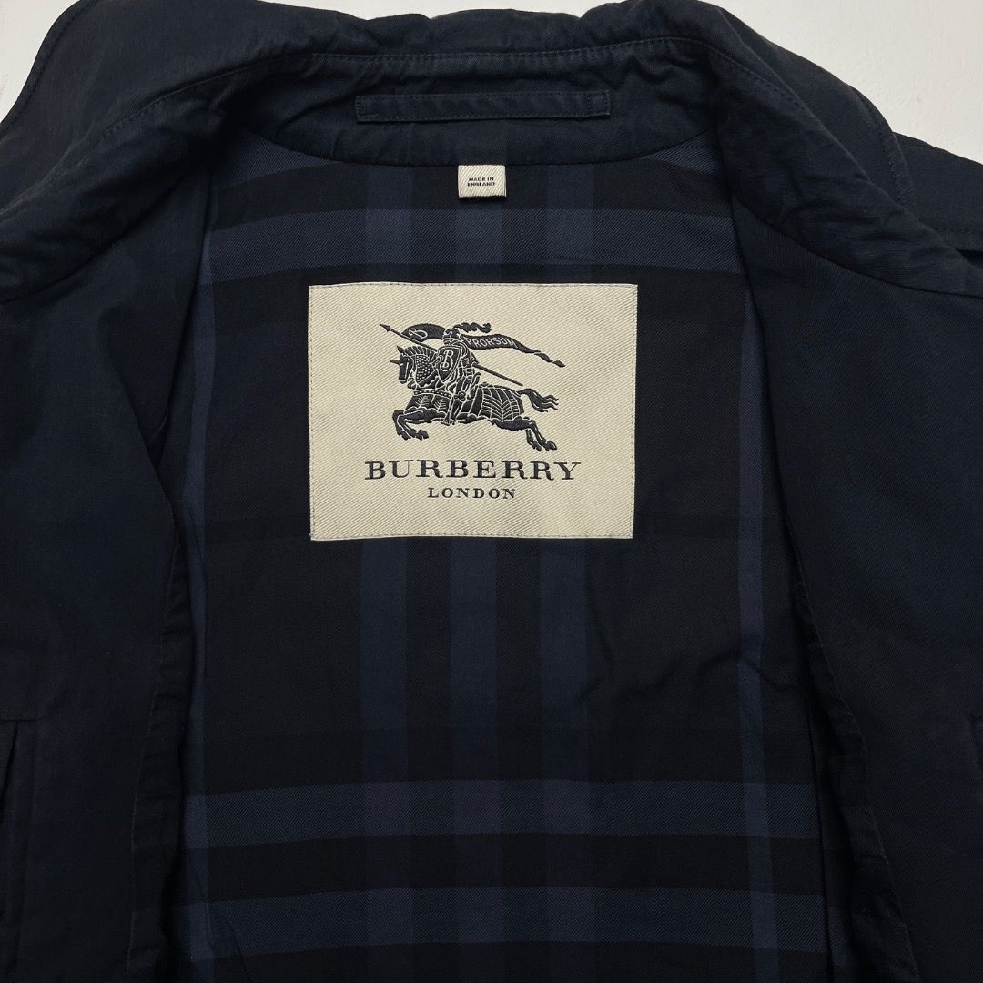 Burberry London Navy Harrington Jacket Size (Category: Coats, Jackets and Outerwear) located in Caloocan City. Submitted by achilles_grails (Listing ID 1470564587, Image 3). Description: - Brand: Burberry London - Color: Dark Navy Blue - Size: 48 R - Material: 100% cotton outer/body lining, 100% viscose sleeve lining - Origin: Made in the UK - Design: Classic check lining, shoulder epaulets, buckled cuffs, and neck button closure - Condition: Pre
