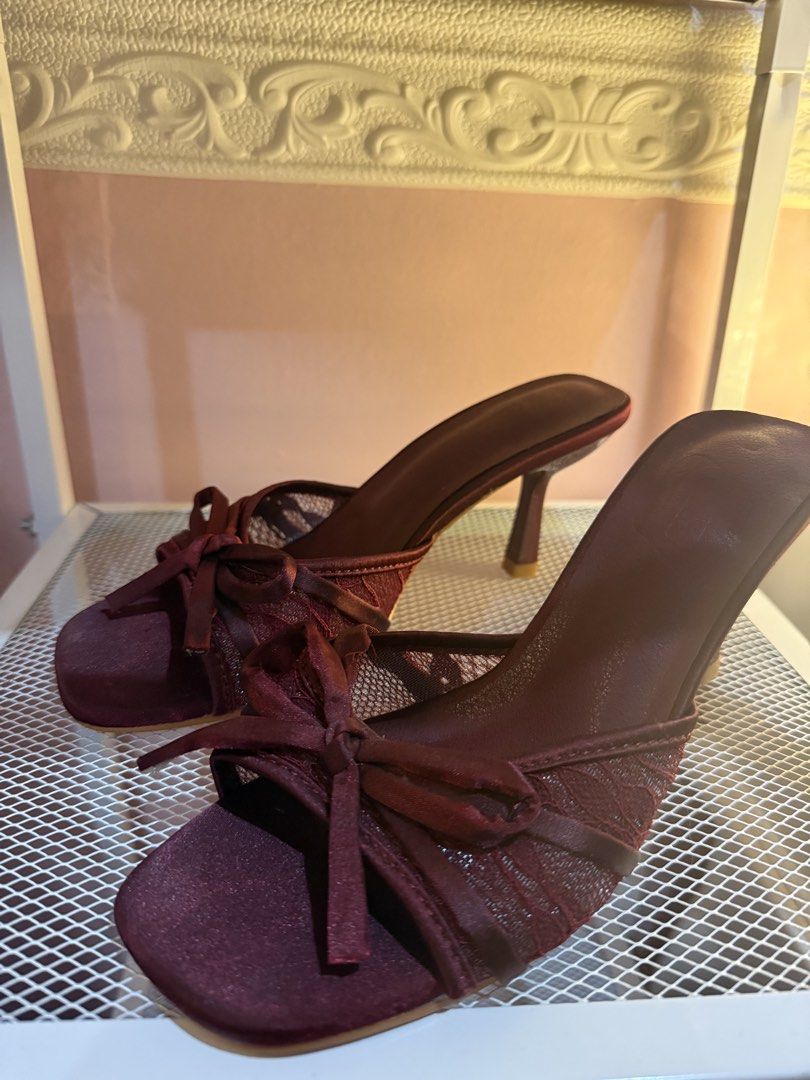 Burgundy satin bow mules heels (Category: Heels) located in Bacoor. Submitted by micsr (Listing ID 1470674469, Image 2). Description: - Style: Slip-on mule heels with slim stiletto - Color: Deep maroon wine / burgundy - Design: Open toe with satin bow detail - Details: Mesh side panels with delicate lace pattern - Occasion: Perfect statement shoes for parties and nights out With minimal flaw, see last photos.