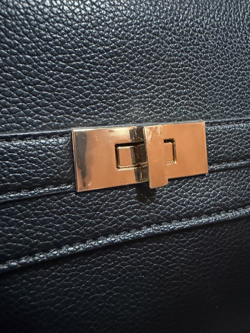 Call it Spring Black Sling Bag (Category: Luxury Bags & Wallets) located in Pasig City. Submitted by aprilluxcloset0812 (Listing ID 1470608696, Image 3). Description: - Structured black handbag with a stylish pebbled texture, with minor scratches in hardware - Elegant gold metal hardware and twist-lock flap closure - Features a convenient top handle and adjustable shoulder strap - Chic diamond-shaped logo plaque on the back - Excellent, clean con