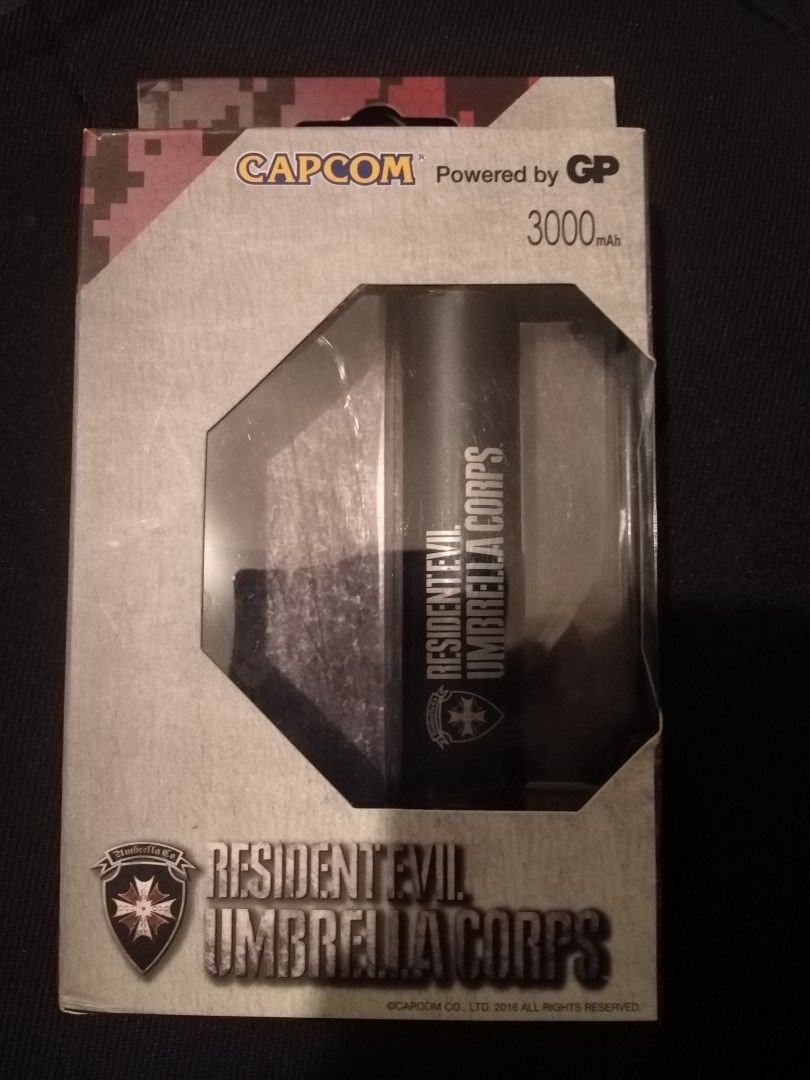 Capcom Resident Evil Umbrella Corps 3000mAh Power Bank (Category: Batteries & Power Banks) located in Cavite. Submitted by emilgarcia09 (Listing ID 1470615604, Image 2). Description: - Authentic Capcom Resident Evil Umbrella Corps merchandise still in original packaging - Reliable 3000mAh capacity powered by GP - Sleek and durable matt aluminum casing - Smart LED power indication - Built-in over-temperature, short circuit, and over-charging prote