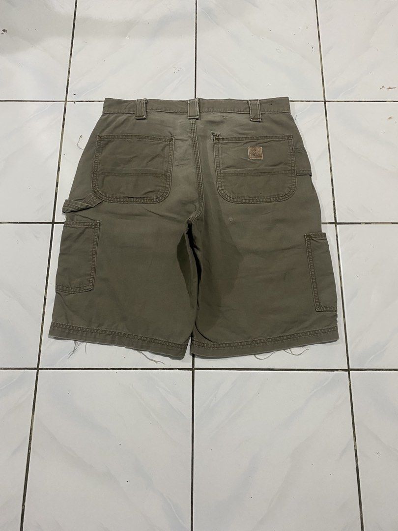 Carhartt Olive Green Cargo Utility Shorts (Category: Shorts) located in Cavite. Submitted by findsmore (Listing ID 1470742686, Image 2). Description: - Brand: Carhartt - Color: Olive Green - Material: Heavy-duty canvas fabric - Features: Multiple cargo pockets, hammer loop, button fly, and belt loops - Detail: Iconic small leather Carhartt logo patch on the back right pocket - Condition: Pre-owned with stylish raw frayed edges at the hems - Perfe