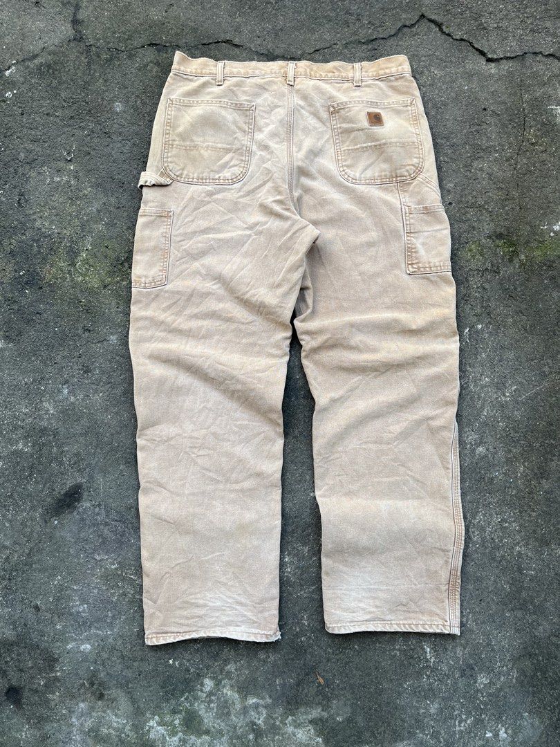 Carousell Carhartt Flannel Lined Duck Work Pants (Category: Jeans) located in Siniloan. Submitted by marceiron316276 (Listing ID 1470665334, Image 2). Description: - Brand: Vintage Carhartt - Color: Tan with blue and brown plaid flannel lining - Material: Thick, heavy-duty duck canvas cotton - Features: Double-knee reinforcement, utility pockets, and hammer loops - Condition: Classic workwear style with natural fading and wear throughout - Perfec