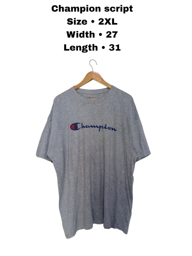 Champion Script Logo Grey T-Shirt 2XL (Category: Tshirts & Polo Shirts ) located in Magdalena. Submitted by magdalenathrift20 (Listing ID 1470671910, Image 1). Description: - Brand: Champion - Color: Grey - Size: 2XL (Width: 27", Length: 31") - Material: 100% cotton, made in Honduras - Condition/Details: Authentic athleticwear with classic crewneck and printed chest script logo.