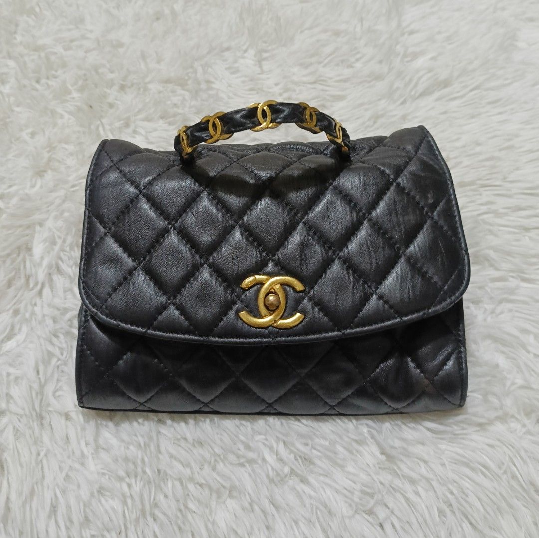 Chanel Black Quilted Leather Handle Flap Bag (Category: Luxury Bags & Wallets) located in Quezon City. Submitted by lootsniwoah_12 (Listing ID 1470630724, Image 1). Description: - Brand: Chanel - Style: Classic flap top handle bag - Material: Black quilted lambskin leather - Hardware: Gold-tone with iconic CC turn-lock closure - Strap/Handle: Short braided chain and leather top handle - Interior: Burgundy lining with a secure zipper pocket - Auth