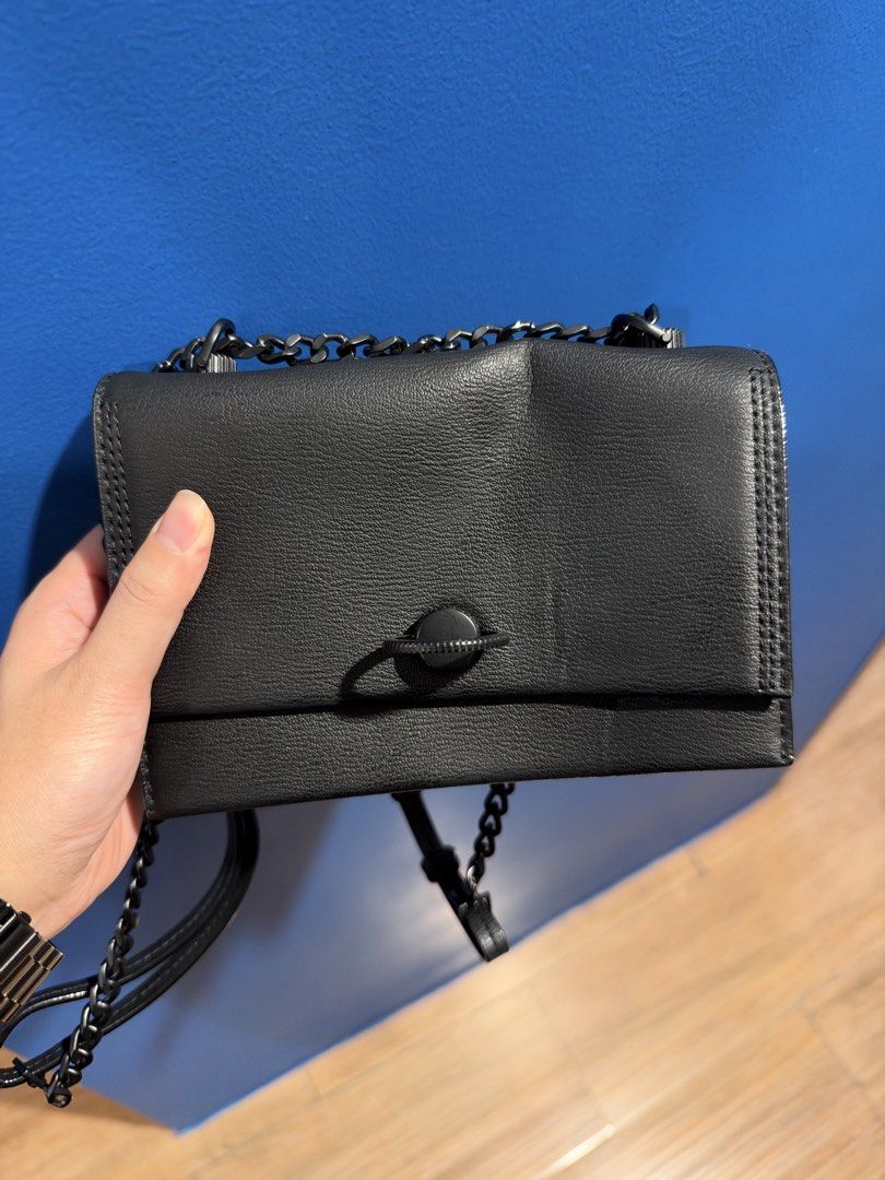 Charles & Keith Black crossbody bag with chain strap (Category: Cross-body Bags) located in Manila. Submitted by garagesalebykoda (Listing ID 1470629031, Image 2). Description: - Color: Sleek black with a stylish grained texture - Closure: Secure front flap with a chic circular toggle clasp - Strap: Fully adjustable dark gunmetal chain and faux leather strap - Size: Compact everyday bag, fits your phone, keys, and essentials with ease - Condition