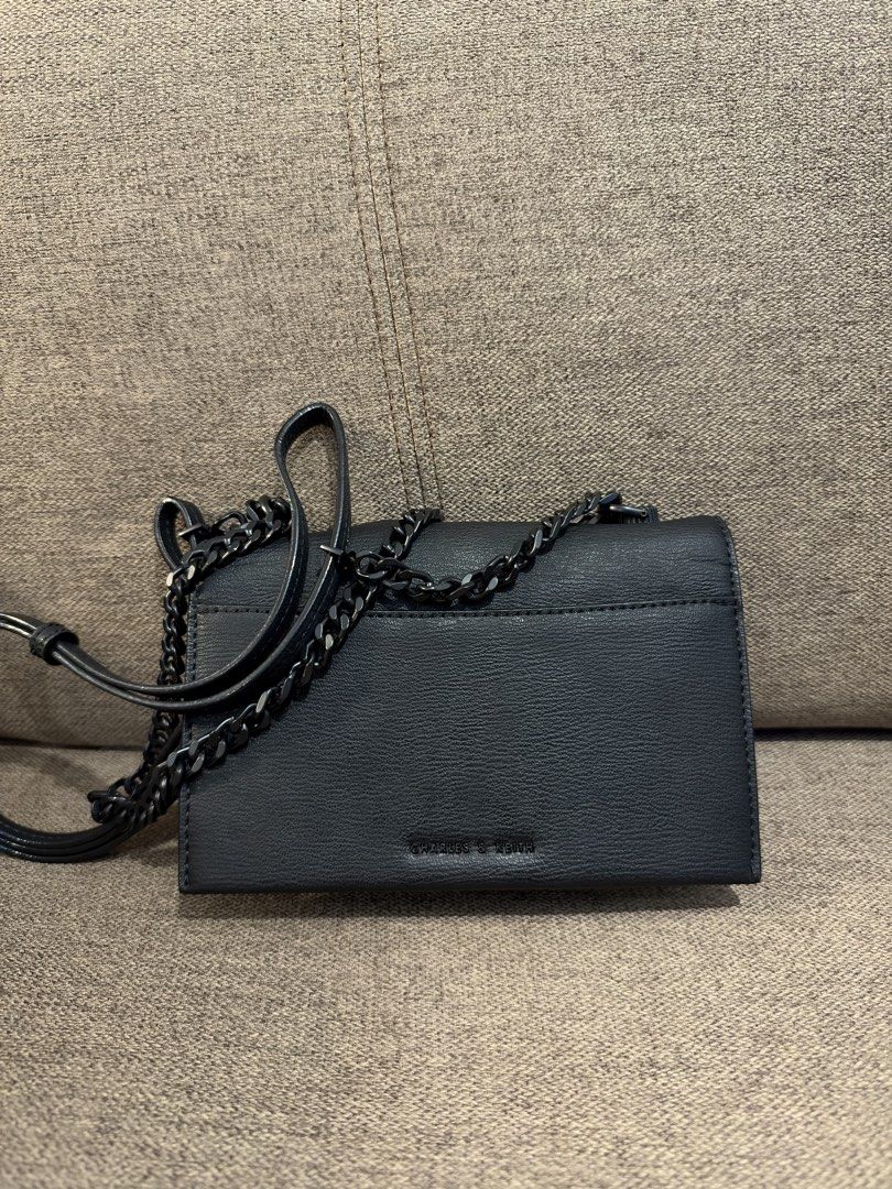 Charles & Keith Black crossbody bag with chain strap (Category: Cross-body Bags) located in Manila. Submitted by garagesalebykoda (Listing ID 1470629031, Image 1). Description: - Color: Sleek black with a stylish grained texture - Closure: Secure front flap with a chic circular toggle clasp - Strap: Fully adjustable dark gunmetal chain and faux leather strap - Size: Compact everyday bag, fits your phone, keys, and essentials with ease - Condition