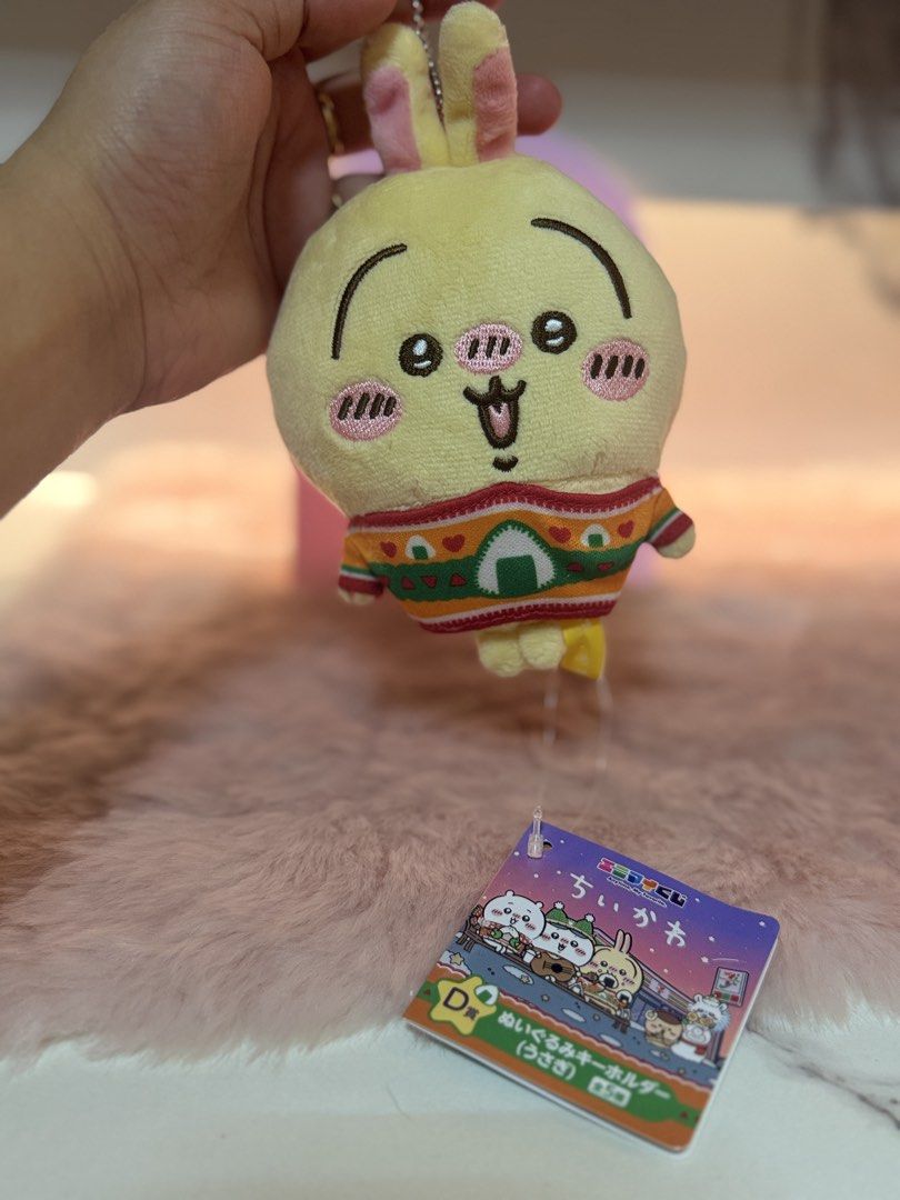 Chiikawa Usagi Plush Keychain D Prize (Category: Plushies & Soft Toys) located in Quezon City. Submitted by parischanelcollection (Listing ID 1470693775, Image 1). Description: - Authentic Chiikawa Usagi plush keychain (Official Lottery D Prize) - Features Usagi wearing an adorable patterned sweater with a rice ball graphic - Soft yellow plush with embroidered face, expression details, and pink cheeks - Includes original hanging tag in crisp, unc