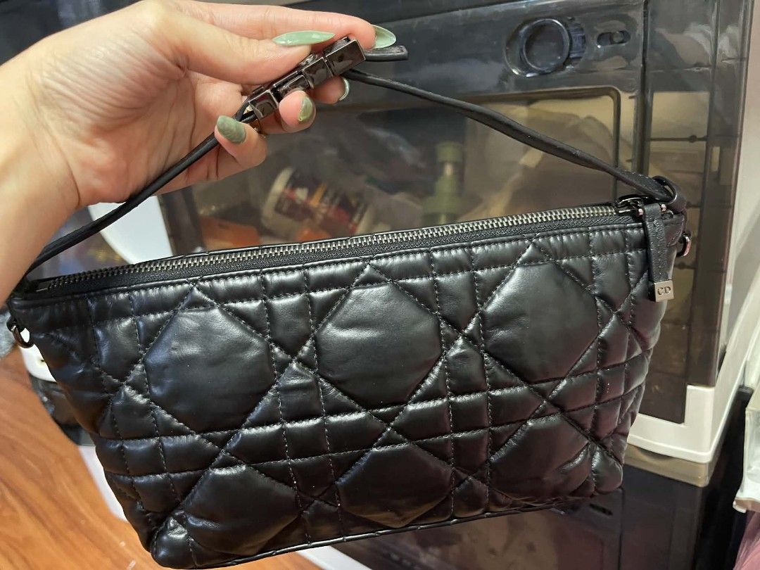 Christian Dior (Category: Clutches) located in Manila. Submitted by jjm-collections (Listing ID 1470727093, Image 2). Description: - Brand: Christian Dior - Model: DiorTravel Nomad Pouch - Material: Black quilted lambskin leather with Cannage pattern - Hardware: Silver-tone with CD zipper pull - Closure: Top zip closure - Strap: Adjustable leather shoulder strap - Interior: Black fabric lining with Christian Dior Made in Italy leather patch tag a