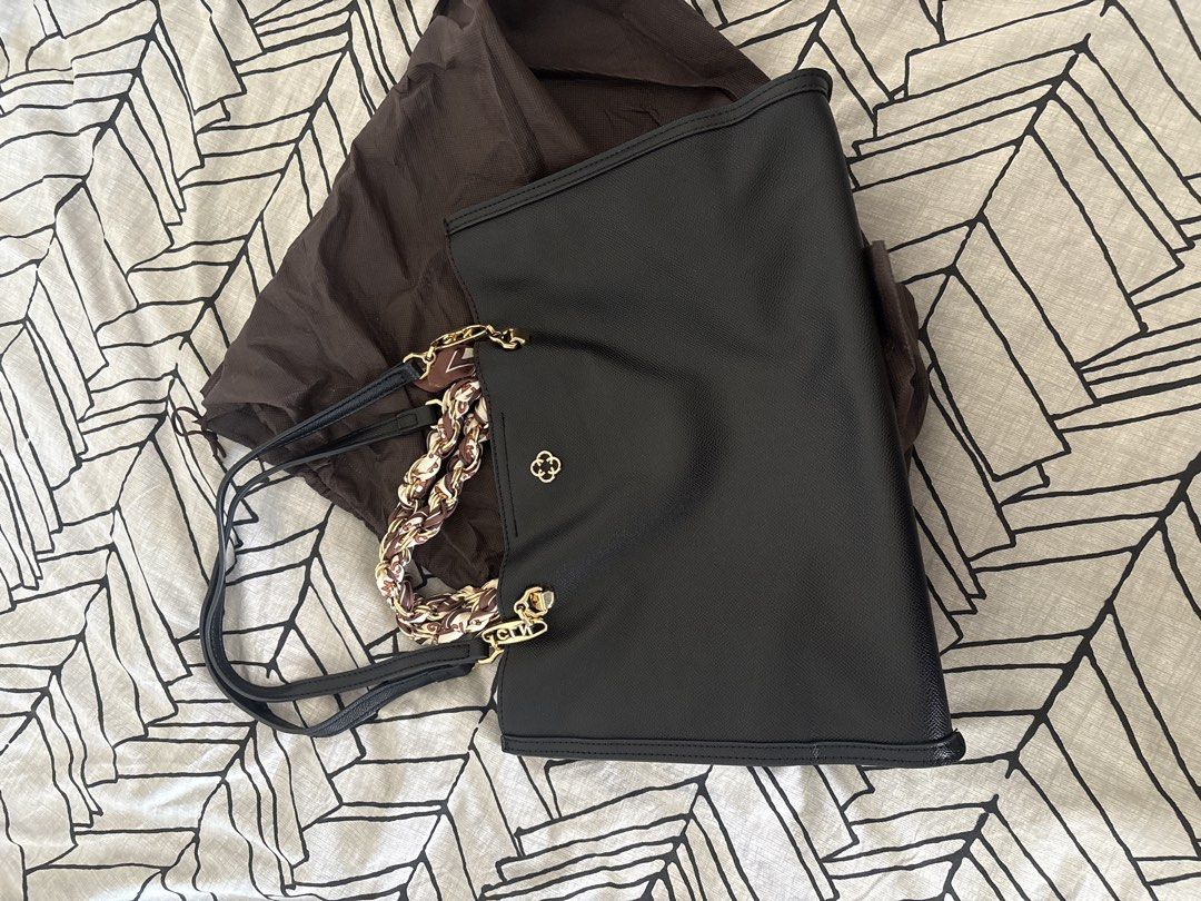 Cln black bag (Category: Tote Bags) located in Las Pinas. Submitted by loveaateles (Listing ID 1470568063, Image 1). Description: - Elegant black textured tote bag with a striking red interior lining - Stylish handles wrapped with a brown and white printed ribbon scarf - Multiple interior compartments and zippered pockets for easy organization - Premium gold-tone hardware details - Includes a matching brown dust bag - Spacious and structured desi