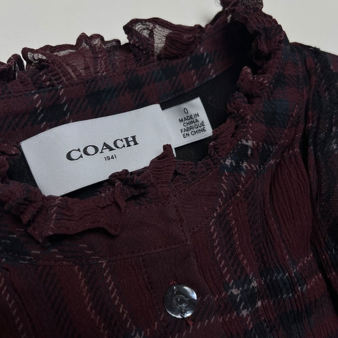 Coach 1941 Maroon Plaid Ruffle High Neck Blouse Size S (Category: Blouses) located in Caloocan City. Submitted by achilles_grails (Listing ID 1470577021, Image 3). Description: - Brand: Coach 1941 - Size: 0 - Color/Pattern: Maroon plaid - Details: High ruffled collar, button-up front with branded buttons, dark lace accents on chest - Versatility: Great for layering or wearing on its own - Condition: Clean inside and out, from a smoke-free home.