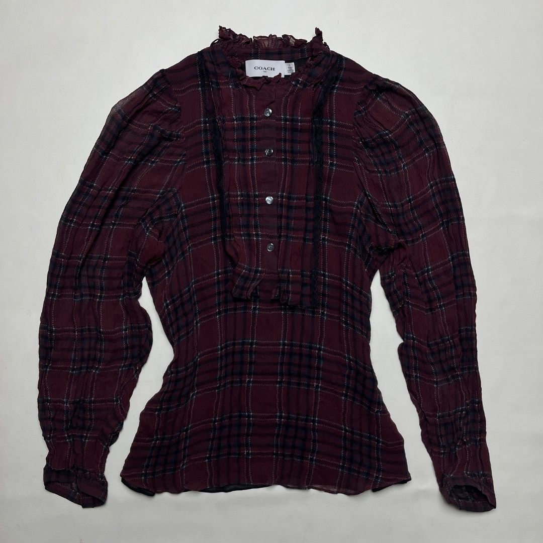 Coach 1941 Maroon Plaid Ruffle High Neck Blouse Size S (Category: Blouses) located in Caloocan City. Submitted by achilles_grails (Listing ID 1470577021, Image 1). Description: - Brand: Coach 1941 - Size: 0 - Color/Pattern: Maroon plaid - Details: High ruffled collar, button-up front with branded buttons, dark lace accents on chest - Versatility: Great for layering or wearing on its own - Condition: Clean inside and out, from a smoke-free home.
