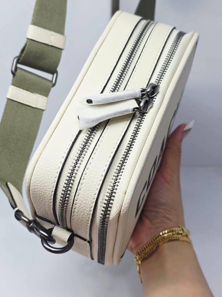 Coach Camera Bag With Round Coin Pouch Off White (Category: Cross-body Bags) located in Manila. Submitted by rachael_23 (Listing ID 1470622865, Image 3). Description: - Authentic Coach camera bag in off-white pebbled leather - Bold black Coach lettering on the front - Double zipped compartments with dark gunmetal hardware - Includes a matching round coin pouch attached to the strap - Adjustable olive green canvas shoulder strap with leather trim 
