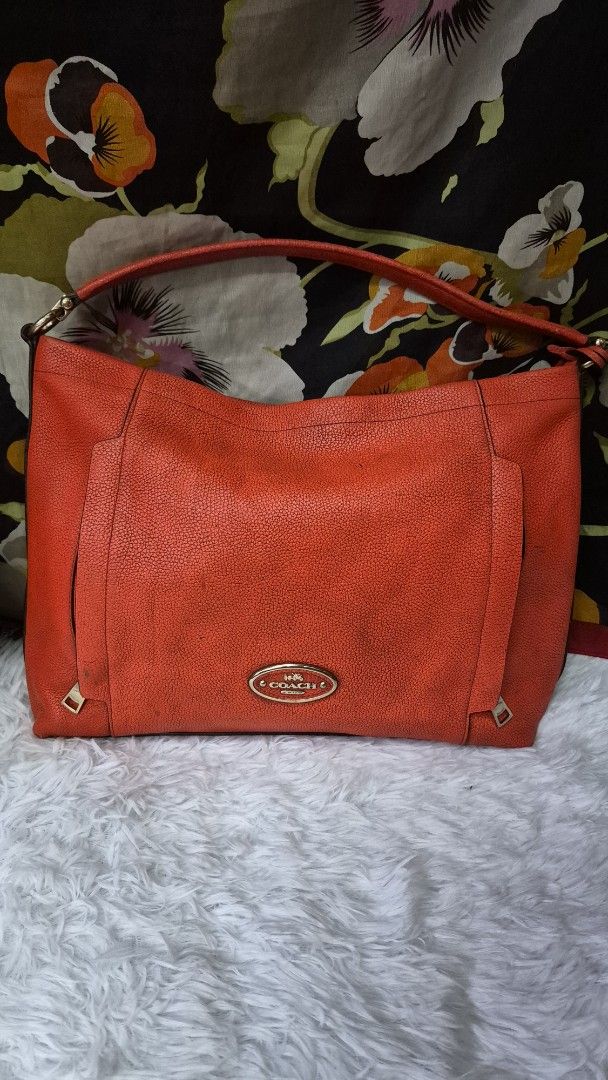 Coach Orange Leather Shoulder Bag (Category: Looking For) located in Baguio. Submitted by jhaz_bags (Listing ID 1470680143, Image 2). Description: Bright orange pebble leather Coach shoulder bag. Gold-tone hardware and metal logo plate on front. Zippered top closure with red fabric lining inside. Interior slip pockets and creed patch. Single strap fits comfortably on the shoulder. Made in Vietnam tag attached inside. Shows minor wear on the leath