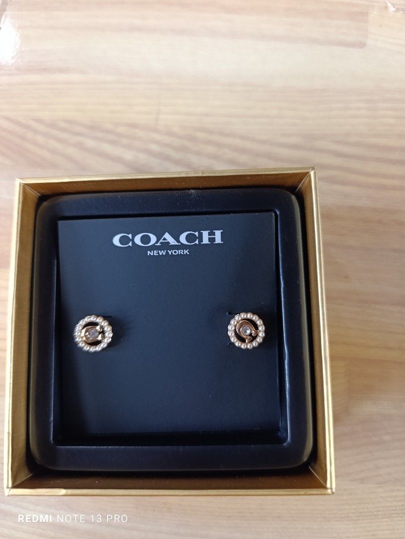Authenthic 💯 Coach Pearl Circle Stud Earrings (Category: Earrings) located in Naguilian. Submitted by jhoyukay (Listing ID 1470687998, Image 3). Description: - Brand: Coach - Design: Gold-tone hardware with crystal center and pearl halo - Details: Signature Coach logo - Condition: Brand new, never worn, pristine - Inclusions: Original Coach presentation box and branded packaging.