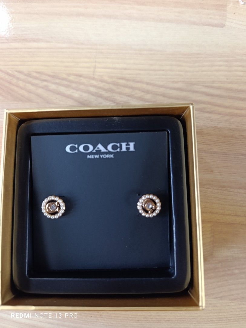 Authenthic 💯 Coach Pearl Circle Stud Earrings (Category: Earrings) located in Naguilian. Submitted by jhoyukay (Listing ID 1470687998, Image 2). Description: - Brand: Coach - Design: Gold-tone hardware with crystal center and pearl halo - Details: Signature Coach logo - Condition: Brand new, never worn, pristine - Inclusions: Original Coach presentation box and branded packaging.