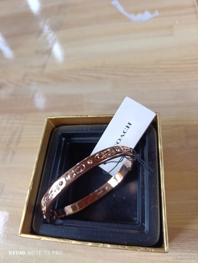 Authenthic 💯 Coach Rose Gold Bangle Bracelet (Category: Bracelets) located in Naguilian. Submitted by jhoyukay (Listing ID 1470687789, Image 1). Description: - Authentic Coach bangle in stunning rose gold - Classic signature C pattern engraved all around with sparkling crystal accents - Convenient and secure hinged clasp closure on the side for easy wear - Features the Coach New York logo stamped on the inner band - Brand new with original brand